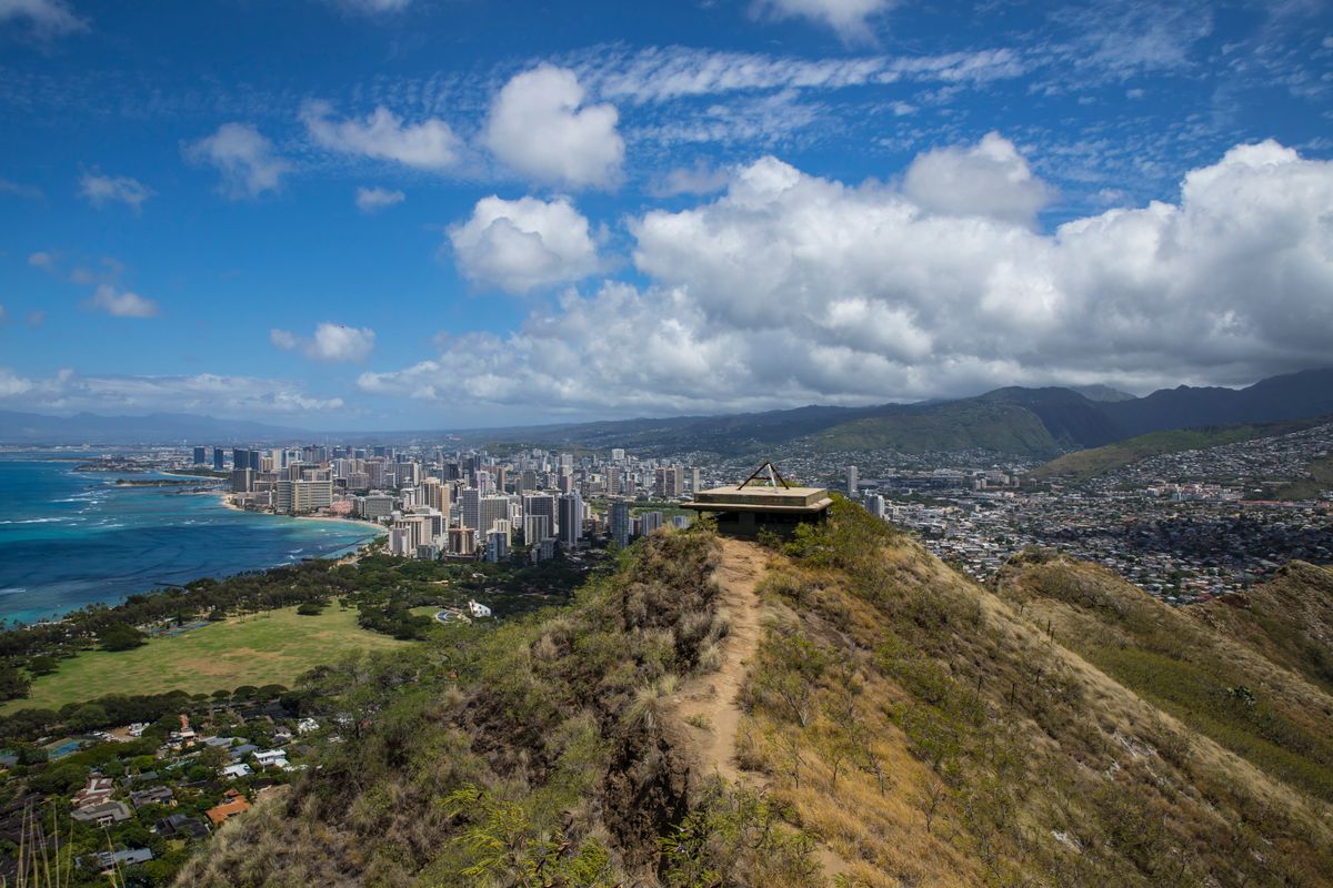 Hikers on the Diamond Head summit trail with Honolulu and the ocean behind them
