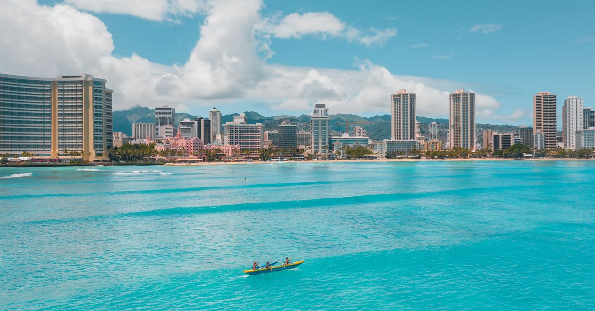 Outrigger canoe with paddlers on turquoise water