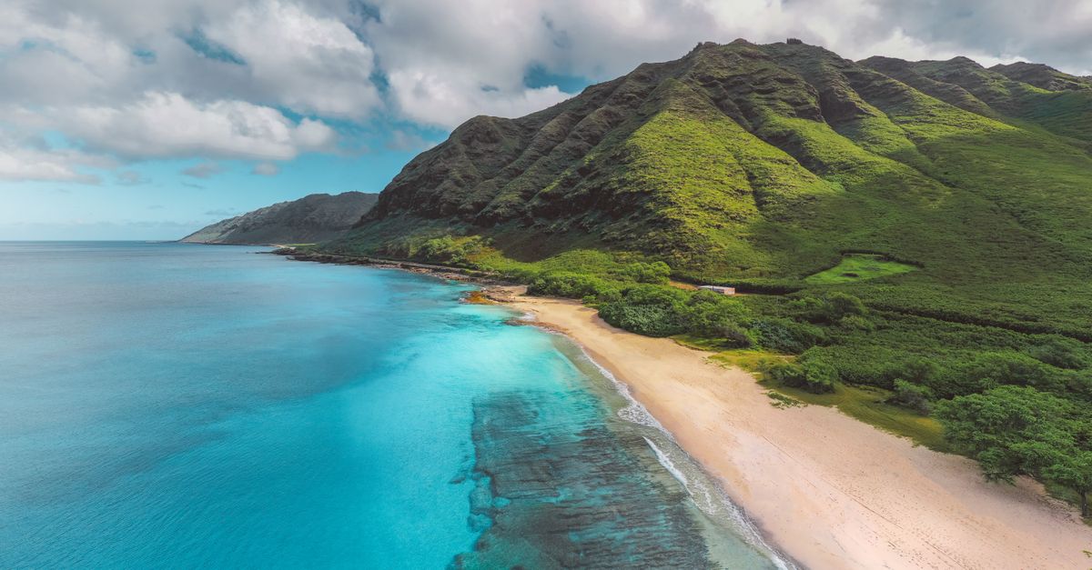 Green mountain meeting the ocean on Oahu's North Shore